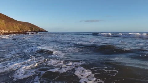 Ocean Waves Washing Along Sunlit Coastal Shore in 4K 库存影片 332944545