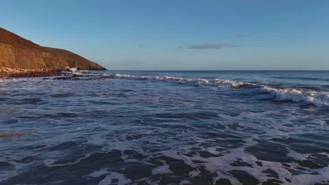 Ocean Waves Washing Along Sunlit Coastal Shore in 4K Stock-Footage 332944550