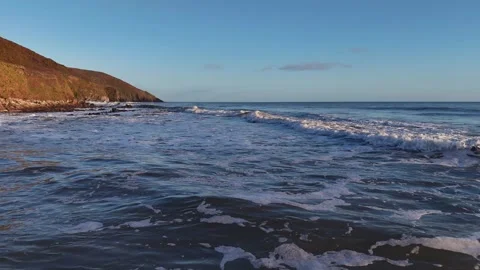 Ocean Waves Washing Along Sunlit Coastal Shore in 4K Video stock 332944565
