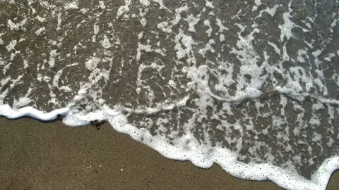 Ocean waves washing away war word written on sand. Stock Footage 311469198