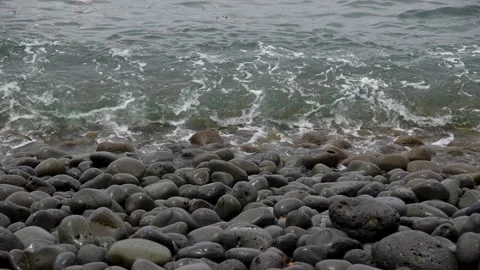 Ocean waves washing over a dark volcanic rock beach.Calm and relaxing seascape Video stock 313602009