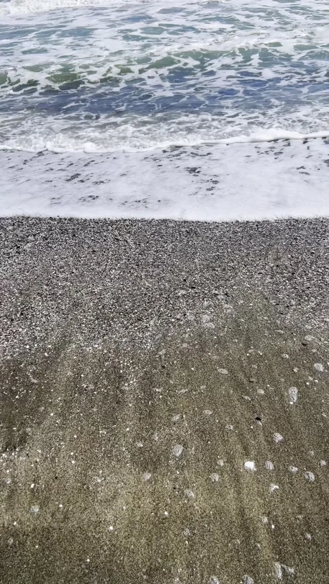 Ocean waves washing over dark sandy beach Video stock 344536733