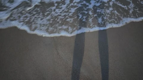 Ocean waves washing over wet sand surface Vídeos de archivo 345697835