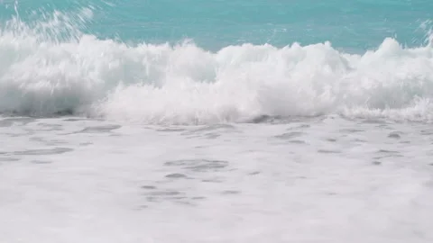 Ocean waves with white foam gently washing over a calm pebble beach Stock Footage 331159290