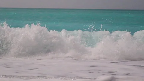 Ocean waves with white foam gently crashing onto a beautiful coastline Vidéo 331200005