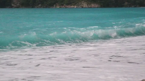 Ocean waves with white foam gently crashing onto a beautiful coastline Stock Footage 331200592