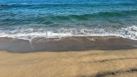 Ocean waves with white foam gently washing over golden sand Stock Footage 341316795