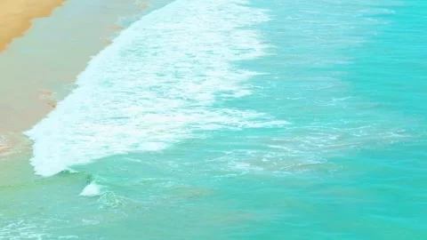 The ocean's waves crash gently on the warm sandy beach. Stock Footage 308054948