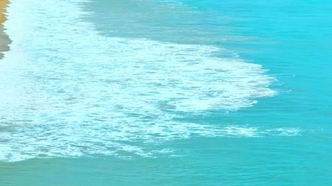 The ocean's waves crash gently on the warm sandy beach. Stock Footage 308054974