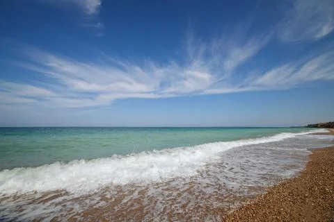 Oceanside under blue sky with clouds Stock Photos