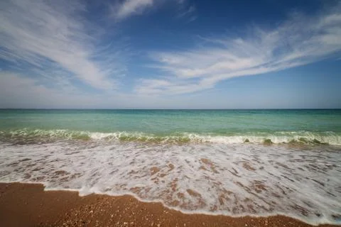 Oceanside under blue sky with clouds Stock Photos