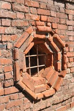 Octagonal window in a brick wall. Stock Photos