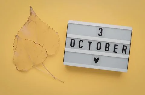 October 3rd date message with yellow leaves on yellow background Stock Photos