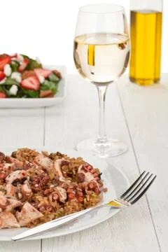 Octopus risotto with fork and wine Stock Photos