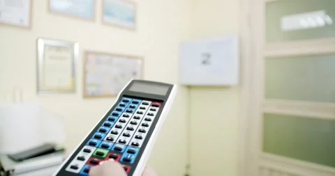 Oculist uses the remote control to control the device checking patients visual Stock Footage 132534387