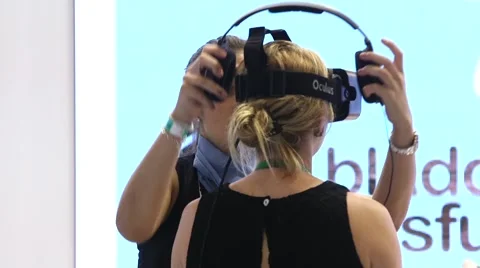 Oculus Rift virtual reality headset on a businessman and businesswoman Stock Footage 56370685