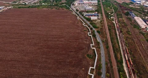 Oddly Shaped Gas Pipe Surrounding Farm Land In Suburban Industrial Area Drone Video stock 300447770
