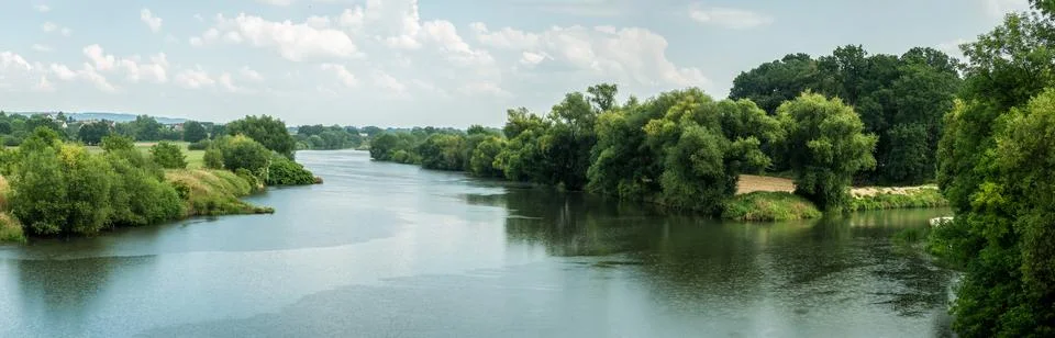 Odra river in summer with slightly cloudy sky and greenery Фото