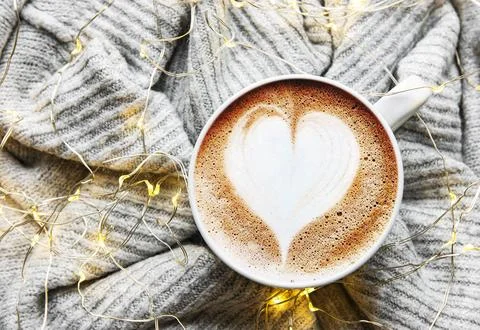 ?offee with a heart pattern on a warm knitted sweater Stock Photos