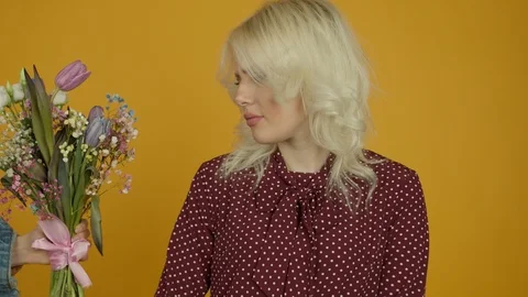 Offended blonde girl refusing tulip bouquet and standing with crossed arms Vidéo 125493141
