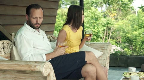 Offended, bored couple sitting onj wooden sofa on terrace HD Stock Footage 55196654