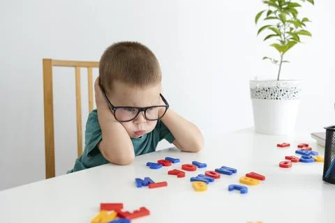 The offended boy learns letters and makes words. Stock Photos