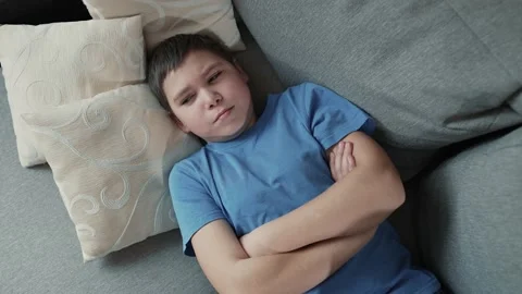 Offended boy lies on the couch Stock Footage 237631748