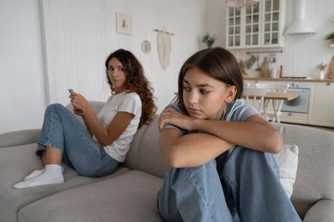 Offended teen girl feeling sad after argument with parent, sitting separately Stock Photos
