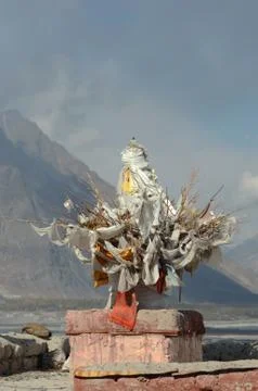 An offering of twigs and flags, at the bottom of a mountain. Stock Photos