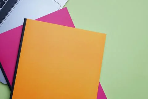 Office and student flat lay. Colorful notebooks and laptop on green backgroun Stock Photos