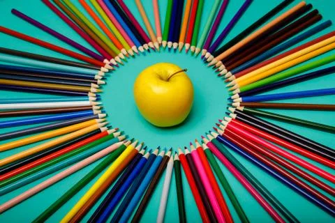 Office background. Apple and colored pencils are laid out in a circle Foto stock