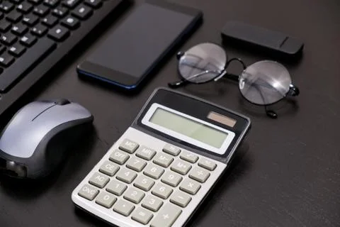 Office black Desk table with computer, calculator, smartphone, glasses, pan Stock-Fotos