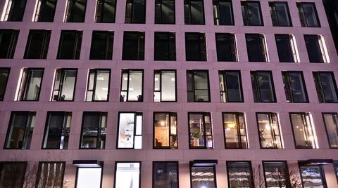 Office building at night; building facade with glass and lights. Stock Photos