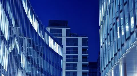 Office building at night; building facade with glass and lights. Stock Photos