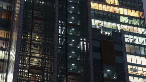 Office building at night, glass elevators moving up and down inside structure Stock Footage 323972613