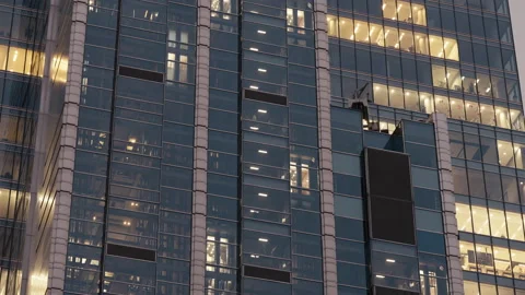 Office building at night, glass elevators moving up and down inside structure Video stock 323973010