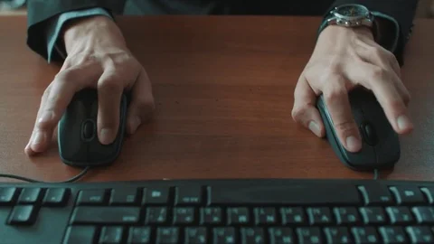 Office clerk in black jacket gray shirt quickly using two computer mices Stock Footage 73609472