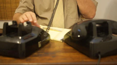 Office clerk - man dials number on old telephone and writes down information. Stock Footage 55912295