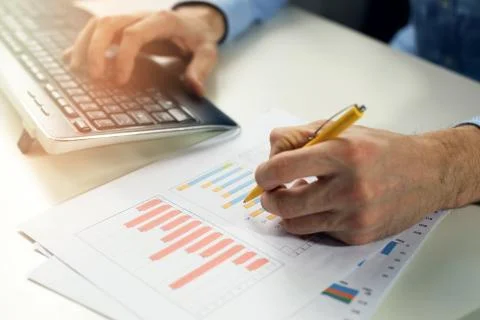 Office clerk working with statistical reports and entering data into a comput Stock Photos