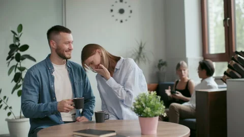 Office co-workers with mugs talk at meeting room. Teamwork of friendly man and y Stock Footage 199485356