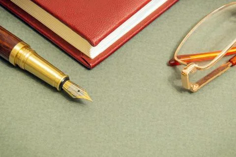 In office dark table with a notebook, glasses and gilt pen businessman prepar Stock Photos