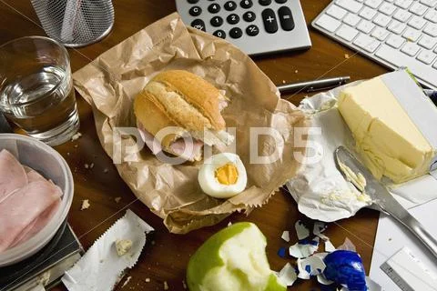 An office desk cluttered with food Stock Photos