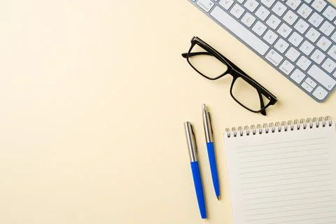 Office desk with computer keyboard, glasses, notebook and pen. Top view wit.. Stock Photos