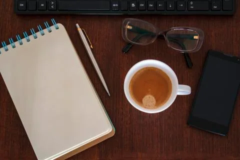 Office desk with notebook, computer, coffee cup, smartphone and glasses Stock Photos