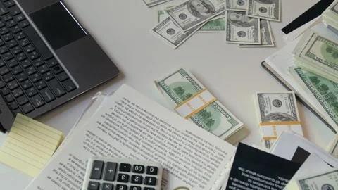 Office Desk with Stacks of Hundred-Dollar Bills, Financial Documents and Laptop Stock Footage 331532158