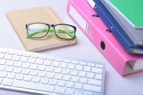 Office desk table with blank notebook, keyboard, other supplies and coffee cup Foto stock