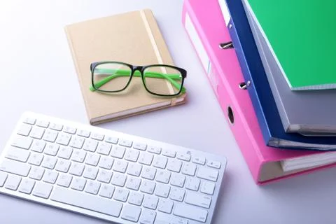 Office desk table with blank notebook, keyboard, other supplies and coffee cup Stock Photos