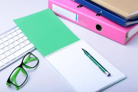 Office desk table with blank notebook, keyboard, other supplies and coffee cup Stock Photos