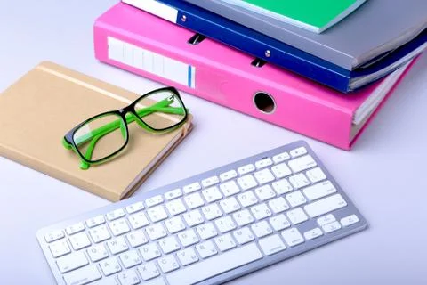 Office desk table with blank notebook, keyboard, other supplies and coffee cup Stock Photos