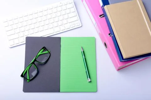 Office desk table with blank notebook, keyboard, other supplies and coffee cup Stock Photos